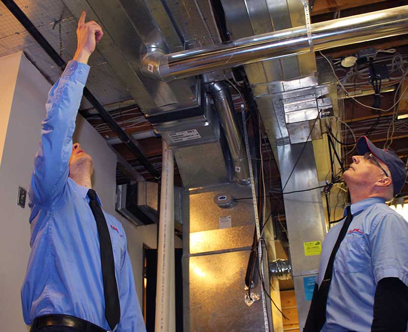 Technicians inspecting air ducts